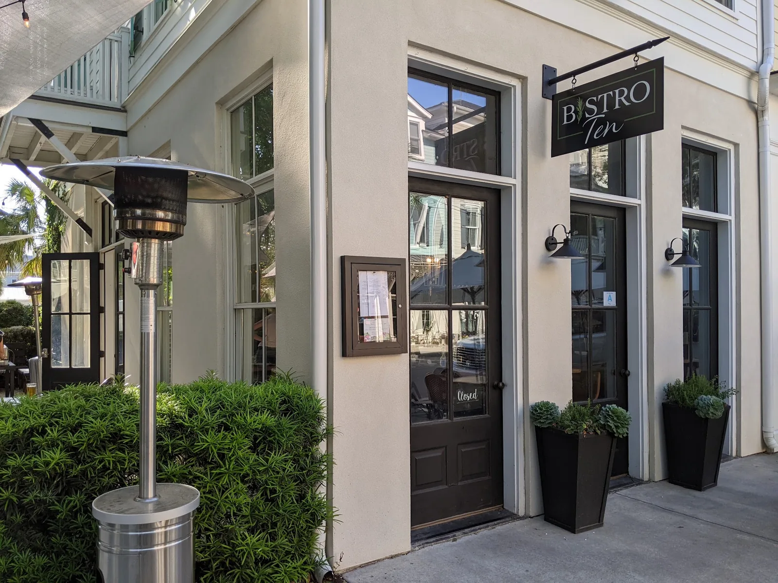 The exterior of Bistro Ten on Market Street with a patio heater and potted topiary