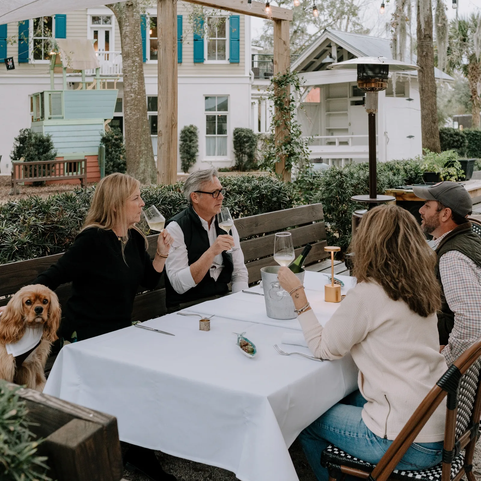 Guests seated at white-clothed tables on the patio at Bistro Ten