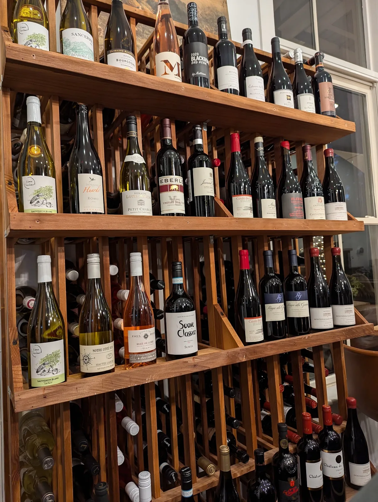 Rows of wine bottles on the wooden shelves at Bistro Ten